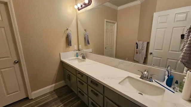a bathroom with a double vanity sink and a mirror