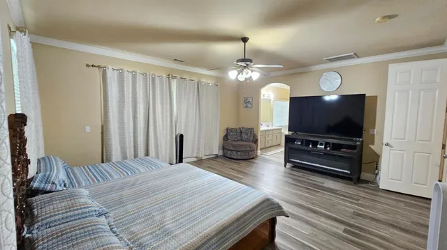 a spacious bedroom with a bed and a flat screen tv
