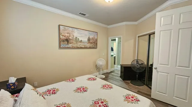 a bedroom with a bed and wooden floor