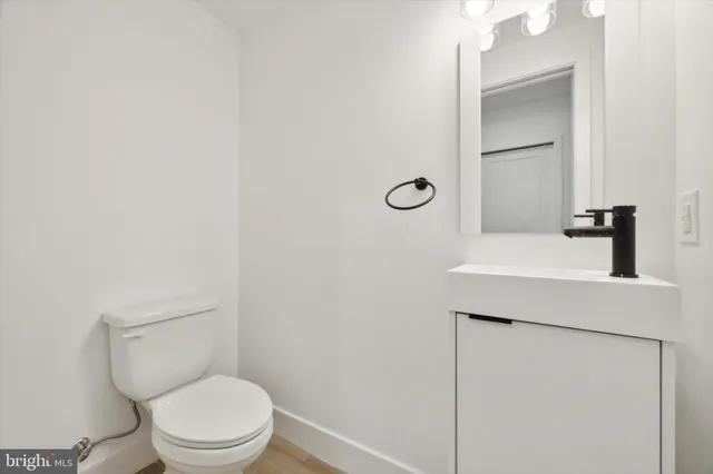 a bathroom with a toilet a sink and mirror