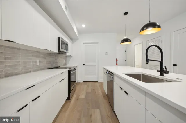 a kitchen with a sink stainless steel appliances and cabinets