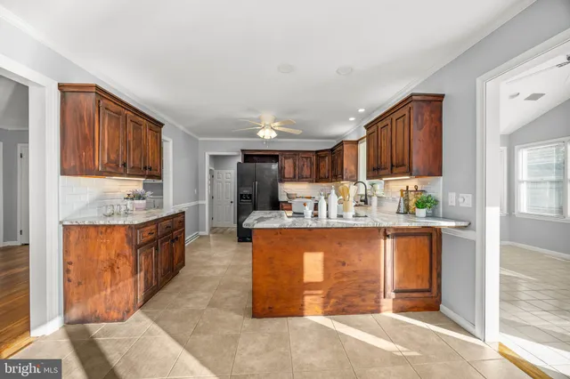 a view of an empty room with window wooden floor and a kitchen