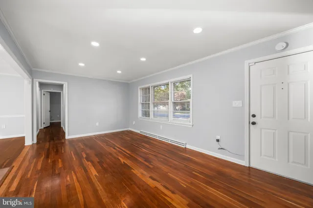 a view of a room with wooden floor and a window