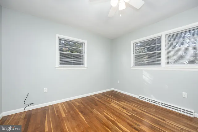 a view of a room with wooden floor and a ceiling fan