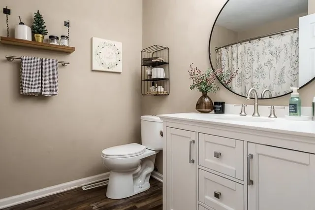 a bathroom with a toilet sink and mirror