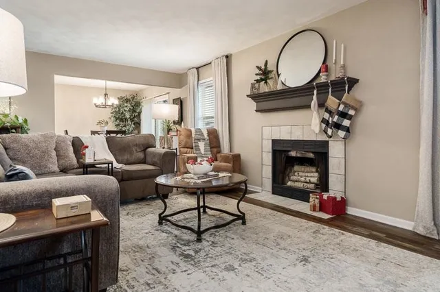 a living room with furniture a fireplace and a window