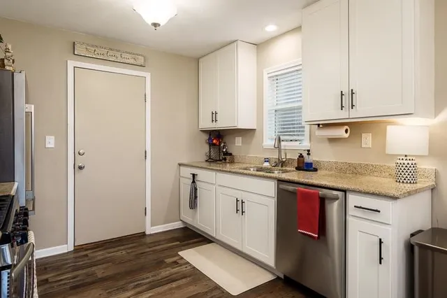 a kitchen with stainless steel appliances granite countertop a sink stove and cabinets