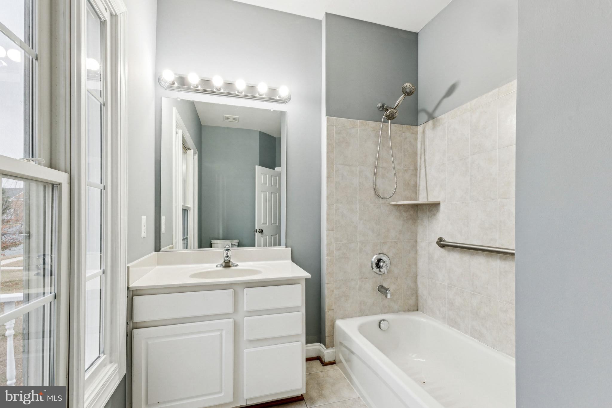 16363 Rusty Rudder Drive Woodbridge, VA 22191 - Photo 26 of 40 a bathroom with a bathtub a sink a mirror a vanity and a shower