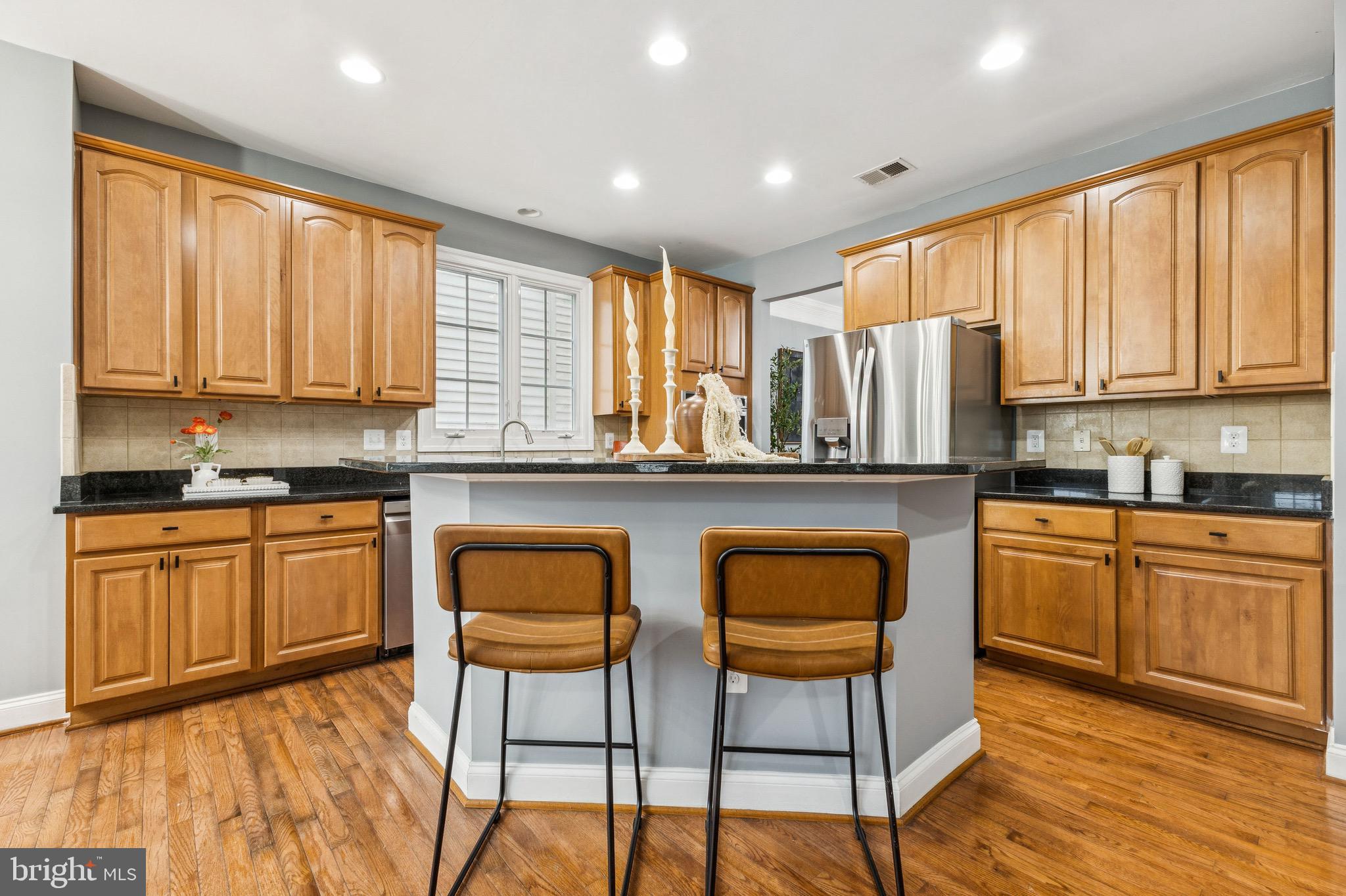 16363 Rusty Rudder Drive Woodbridge, VA 22191 - Photo 10 of 40 a kitchen with stainless steel appliances granite countertop a stove a sink dishwasher a dining table and chairs with wooden floor