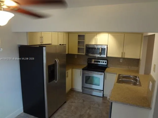 a kitchen with stainless steel appliances granite countertop a refrigerator and a stove