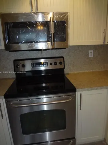 a stove top oven sitting inside of a kitchen