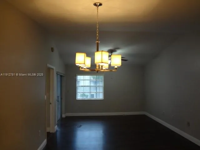 a view of a room with wooden floor chandelier and window
