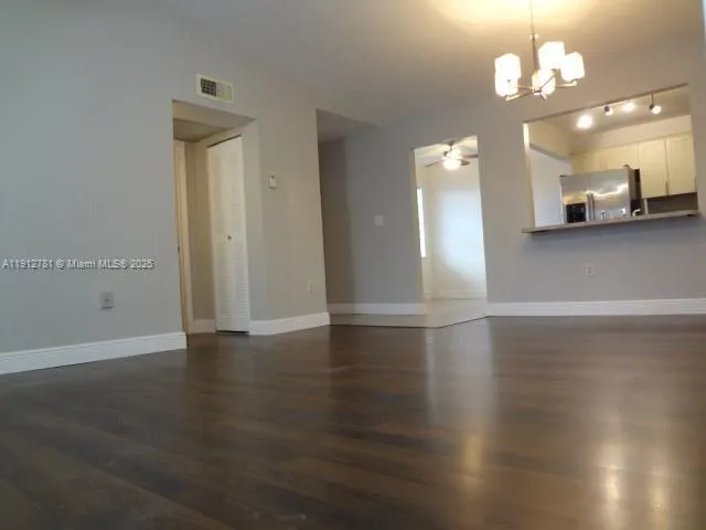 a view of a room with wooden floor and a ceiling fan