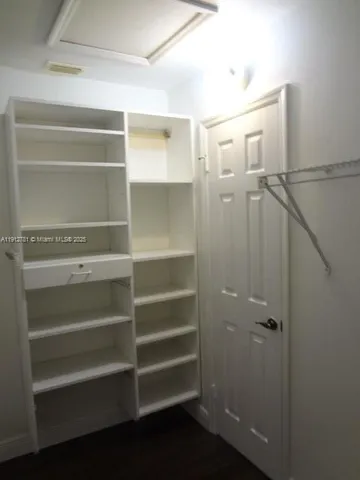 a view of walk in closet with empty racks