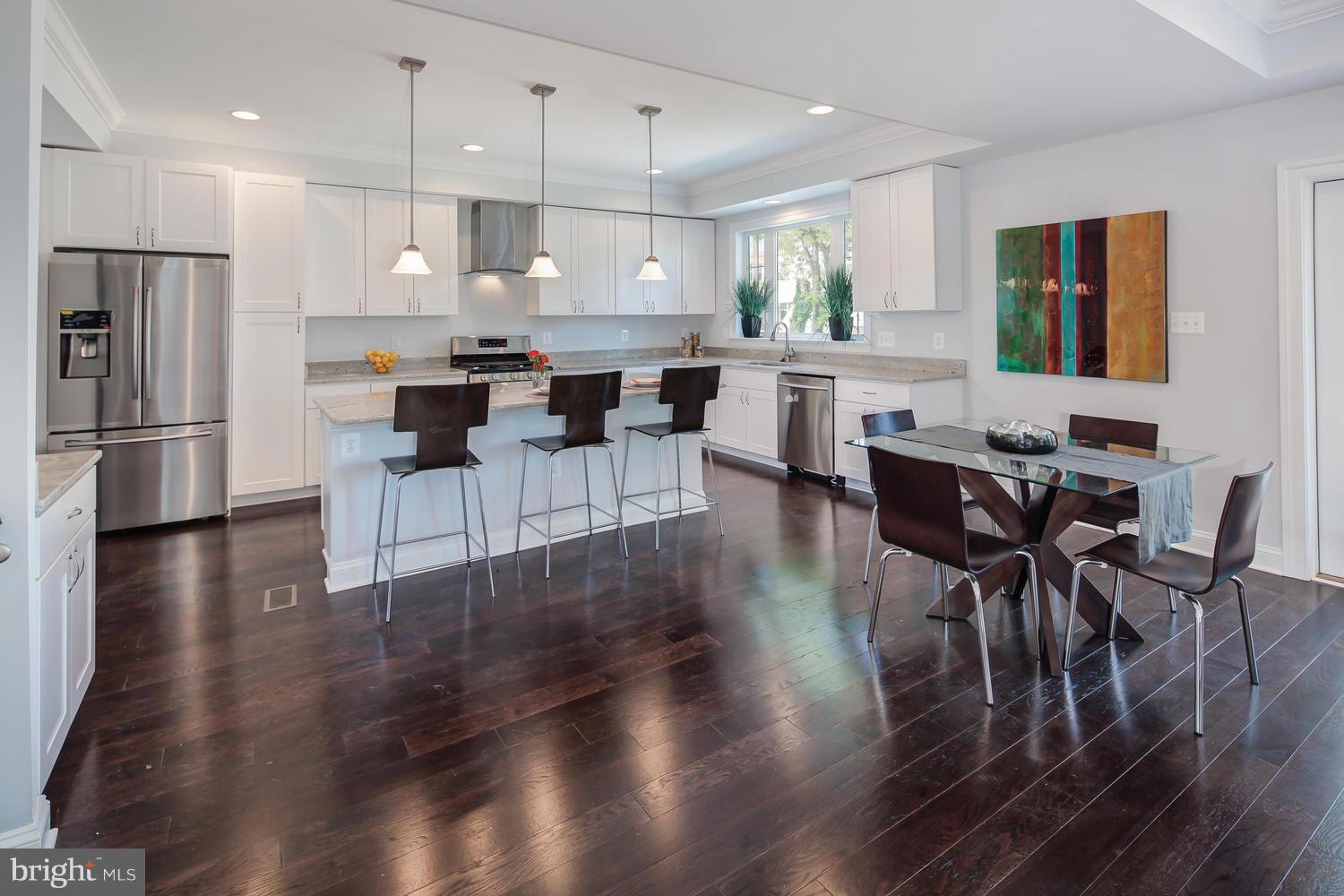 859 Venable Place Northwest Washington, DC 20012 - Photo 11 of 30 a kitchen with stainless steel appliances a dining table chairs refrigerator and sink