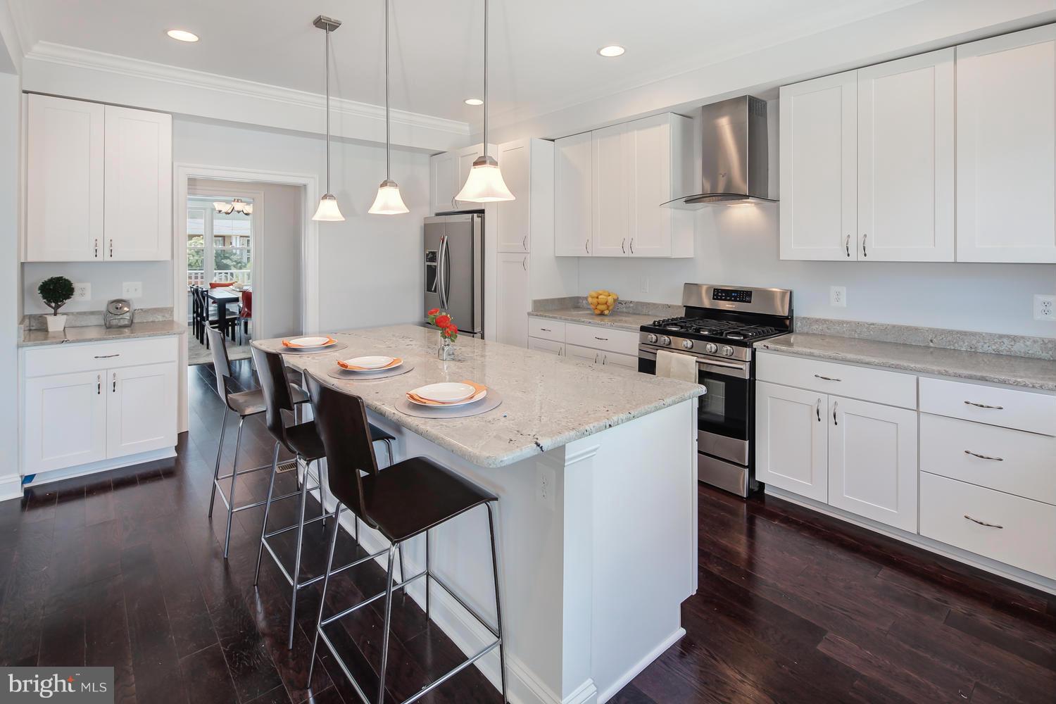 859 Venable Place Northwest Washington, DC 20012 - Photo 15 of 30 a kitchen with stainless steel appliances kitchen island a white table chairs and a refrigerator