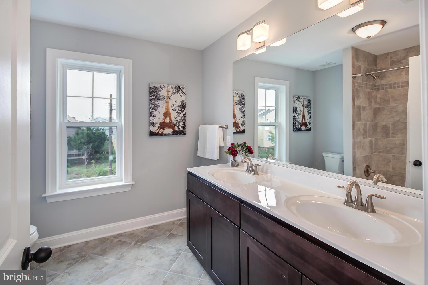 859 Venable Place Northwest Washington, DC 20012 - Photo 24 of 30 a bathroom with double vanity sinks a mirror and a window