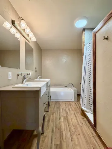 a bathroom with a double vanity sink mirror and bathtub