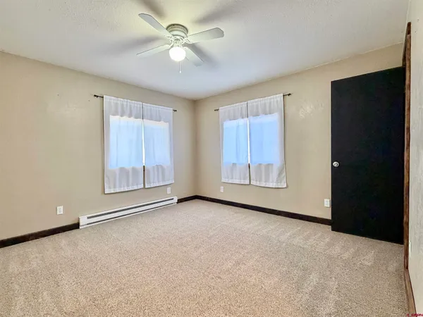 a spacious bedroom with a bed a couch and a potted plant