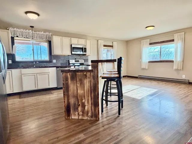 a kitchen with stainless steel appliances granite countertop a stove top oven a sink dishwasher and a refrigerator