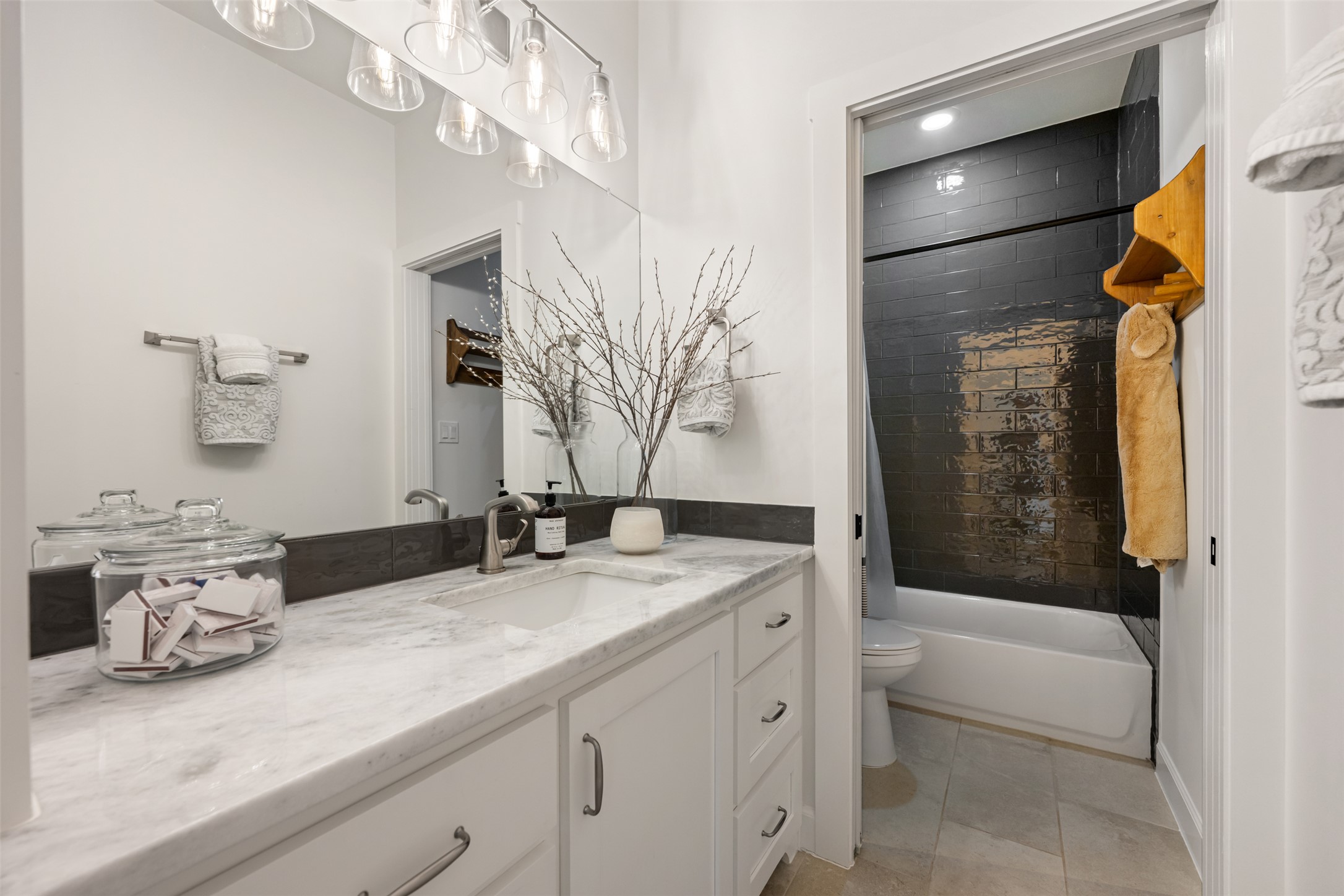 1301 West Street Georgetown, TX 78626 - Photo 36 of 40 A well-lit bathroom with a bright vanity and sleek dark tile shower.