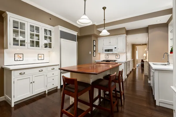 a kitchen with a dining table chairs cabinets and stainless steel appliances