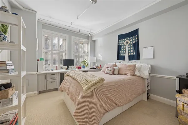 a bedroom with a bed and a large window