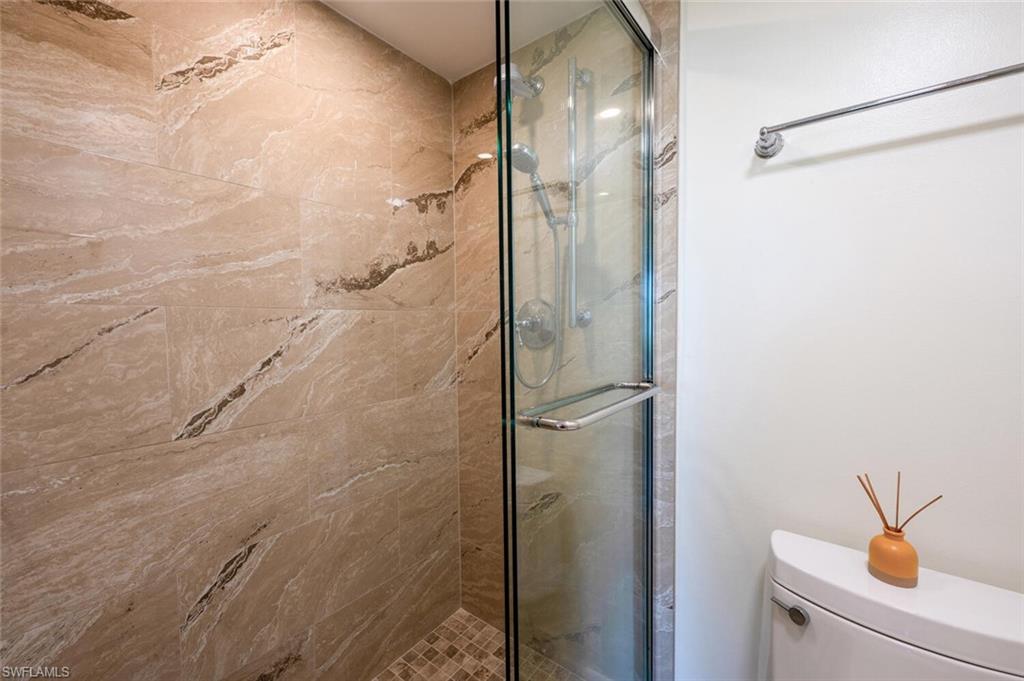 3055 Riviera Drive, Unit 306 Naples, FL 34103 - Photo 11 of 26 Bathroom featuring a stall shower and toilet