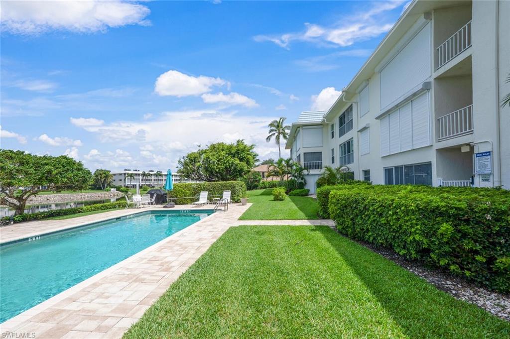 3055 Riviera Drive, Unit 306 Naples, FL 34103 - Photo 15 of 22 Community pool featuring a yard and a patio