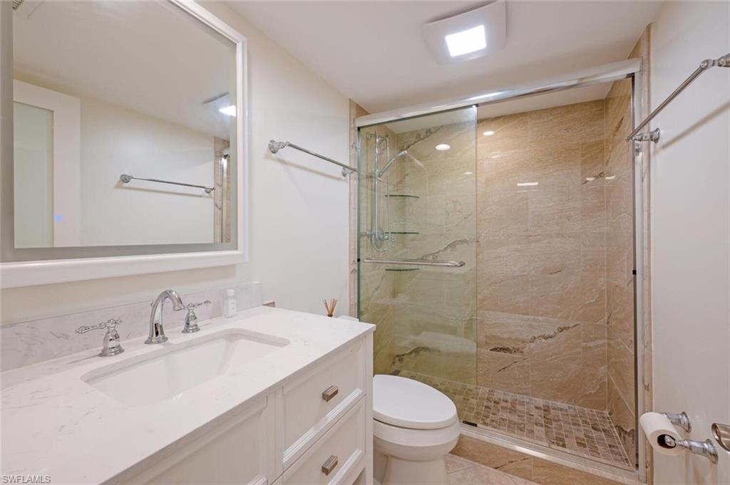 3055 Riviera Drive, Unit 306 Naples, FL 34103 - Photo 15 of 26 Bathroom featuring vanity and a shower stall