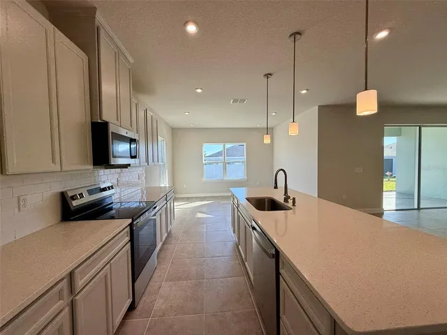a kitchen with stainless steel appliances a stove sink and cabinets