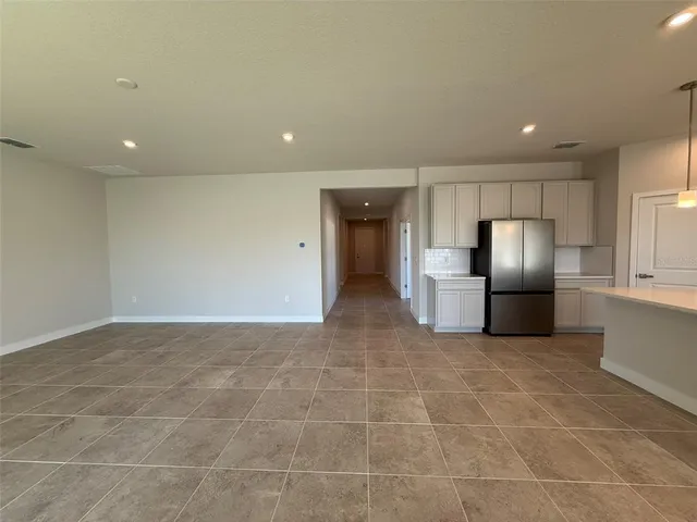 a view of kitchen with refrigerator and wooden floor