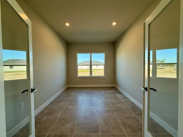 a view of a hallway with a glass door and chandelier