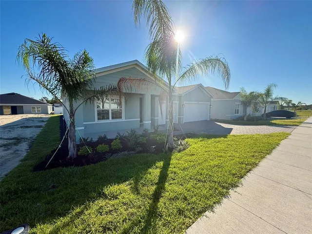 a view of a house with a yard and potted plants