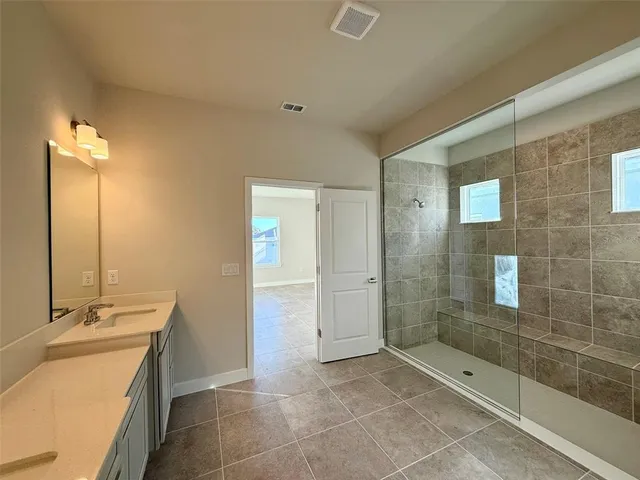 a bathroom with a granite countertop sink a mirror and a shower