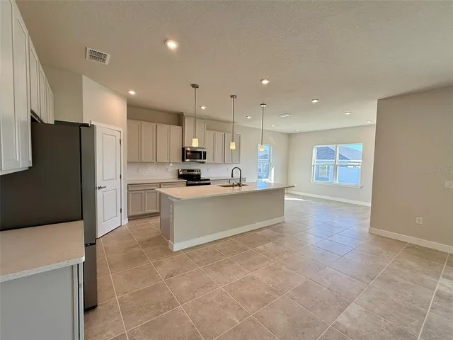 a large kitchen with a large counter top appliances and cabinets