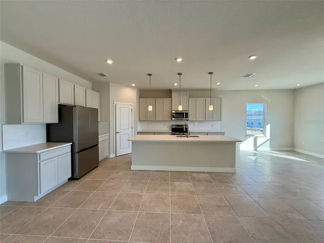 a large kitchen with stainless steel appliances a large counter top and a stove