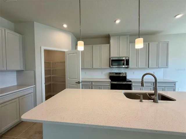 a kitchen with stainless steel appliances a sink a microwave a stove and cabinets