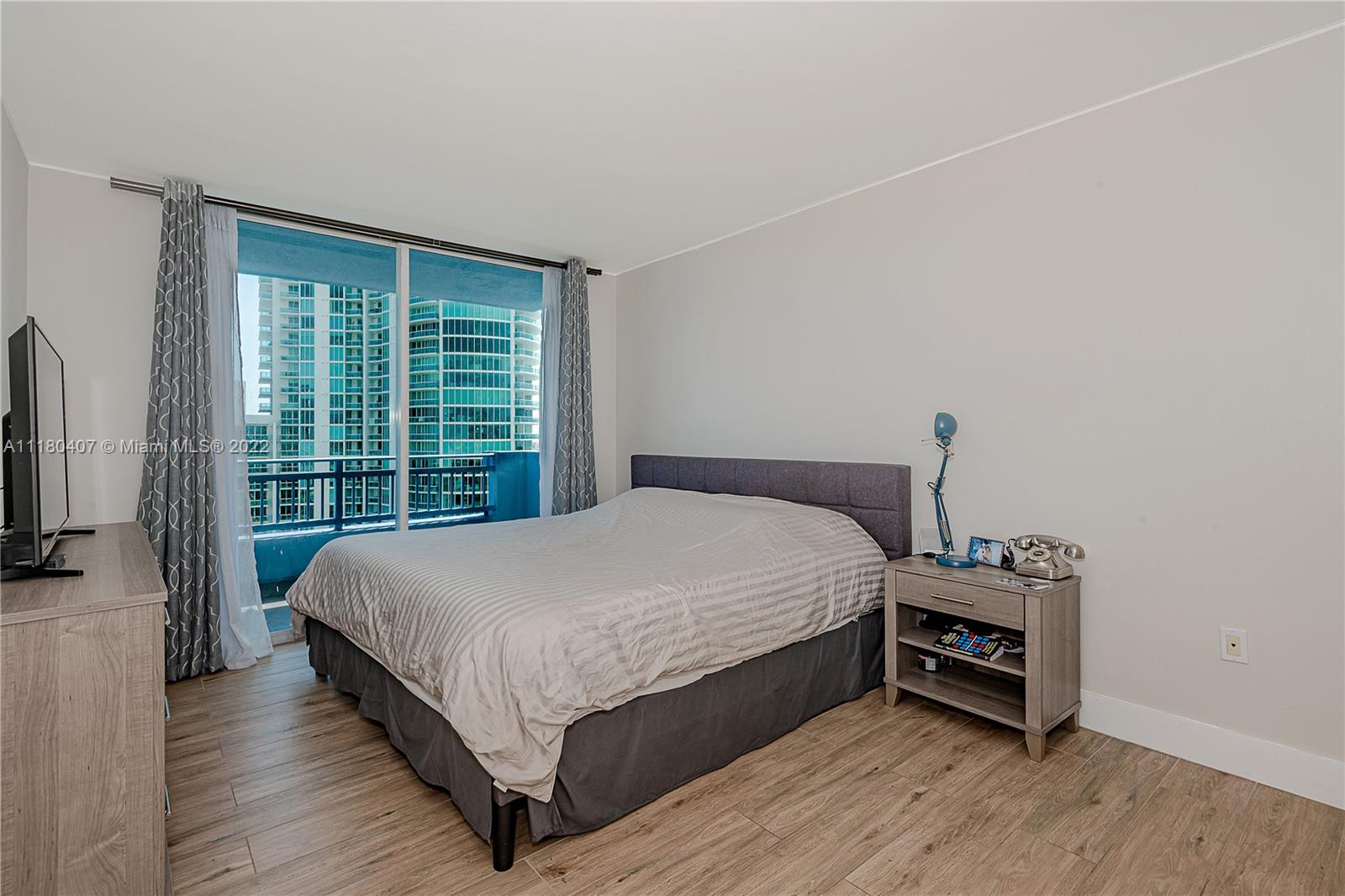 90 Alton Road, Unit 1901 Miami Beach, FL 33139 - Photo 13 of 21 a bed sitting in a bedroom next to a window
