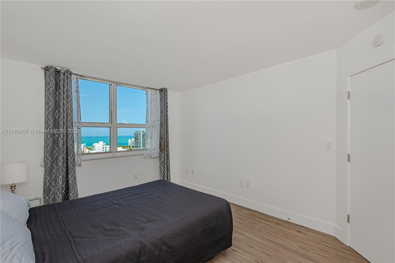 90 Alton Road, Unit 1901 Miami Beach, FL 33139 - Photo 17 of 21 a bedroom with a bed and window