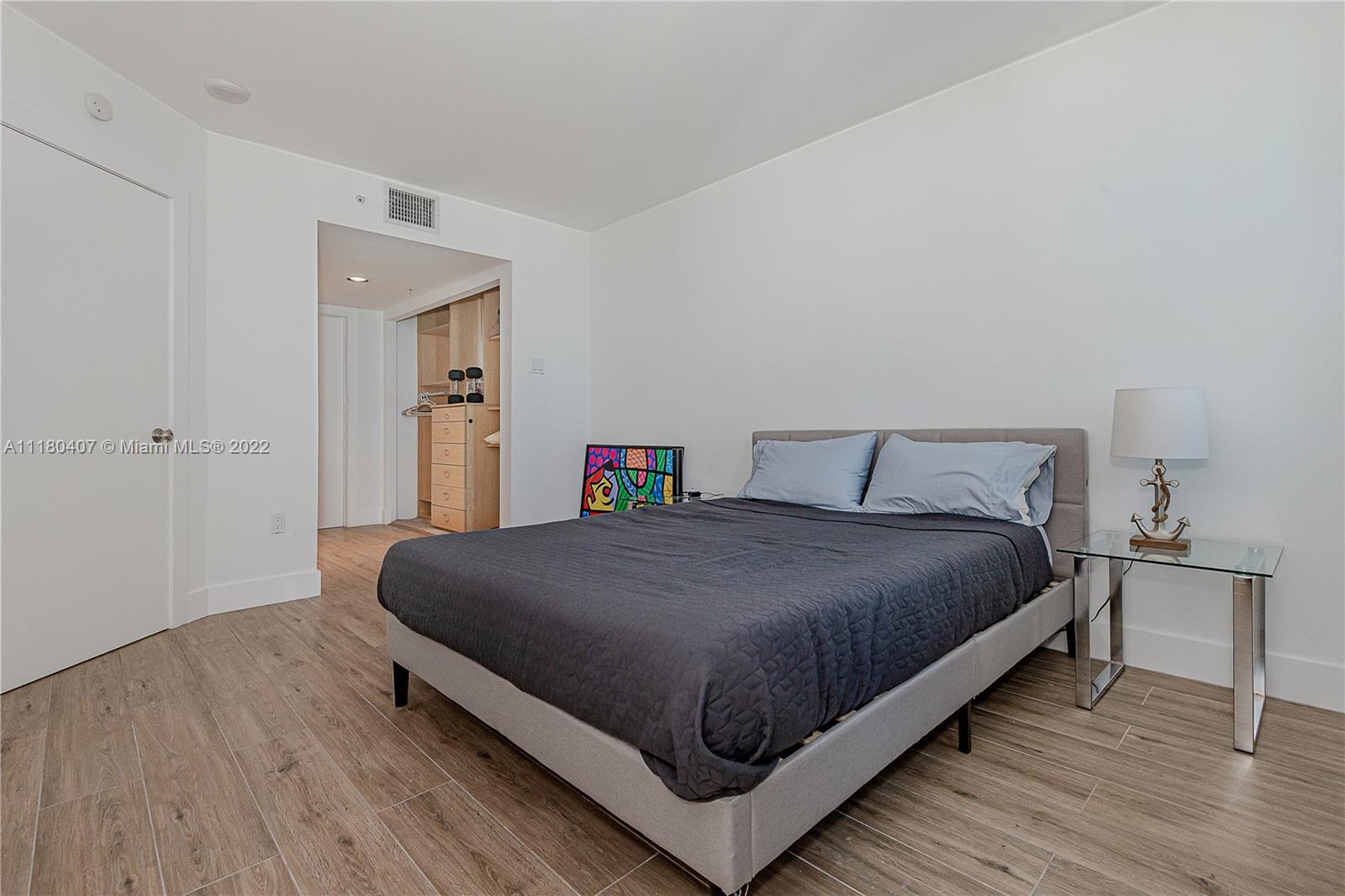 90 Alton Road, Unit 1901 Miami Beach, FL 33139 - Photo 18 of 21 a bedroom with a bed and wooden floor