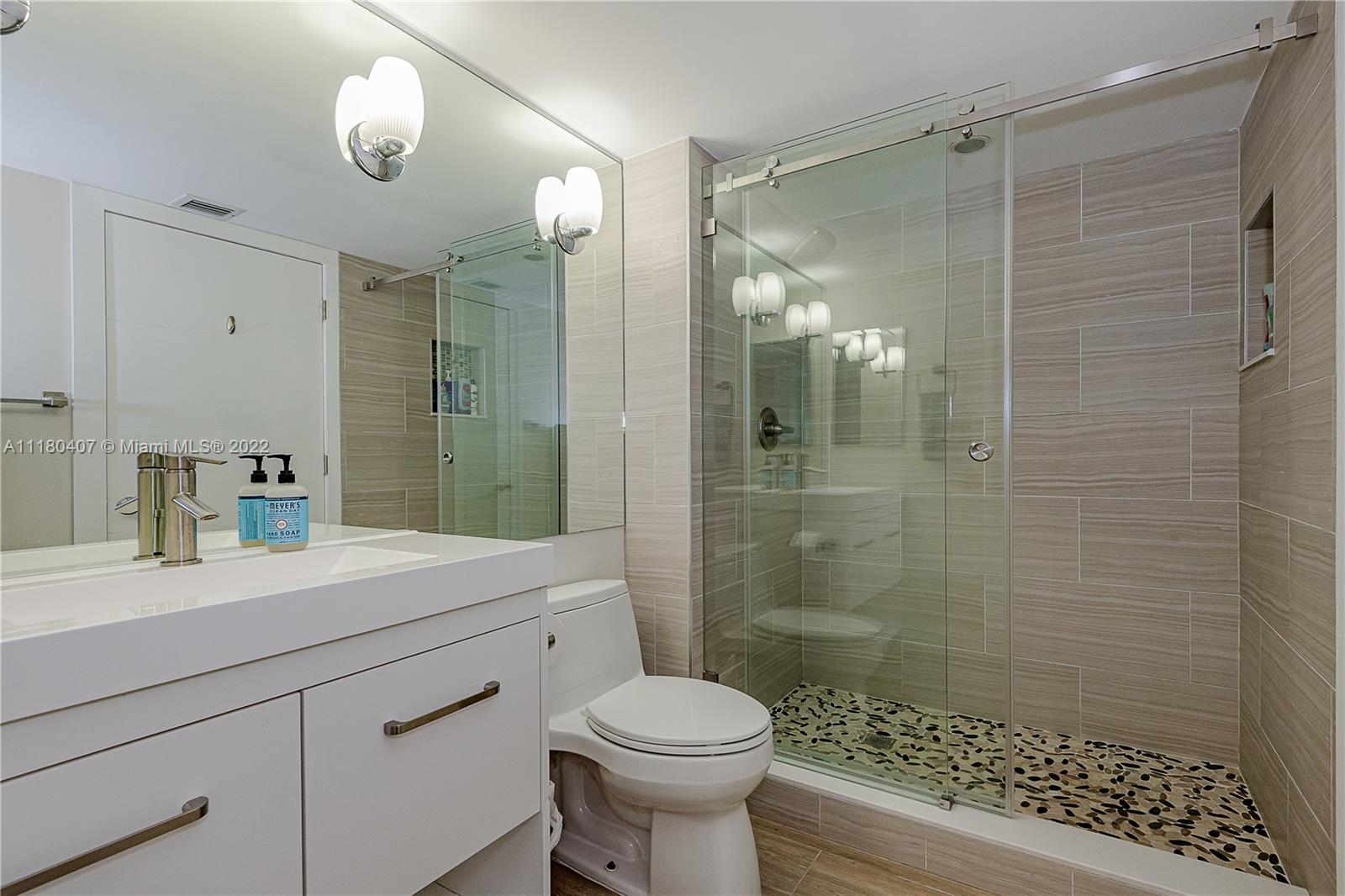 90 Alton Road, Unit 1901 Miami Beach, FL 33139 - Photo 19 of 21 a bathroom with a sink toilet a mirror and shower