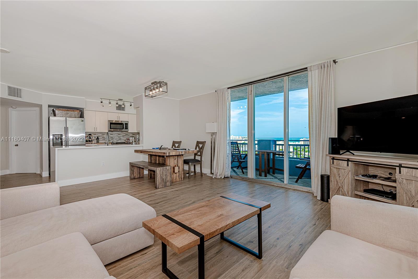 90 Alton Road, Unit 1901 Miami Beach, FL 33139 - Photo 9 of 21 a living room with furniture and a flat screen tv