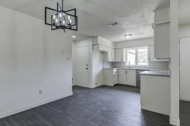 a view of a kitchen with a sink dishwasher and wooden floor