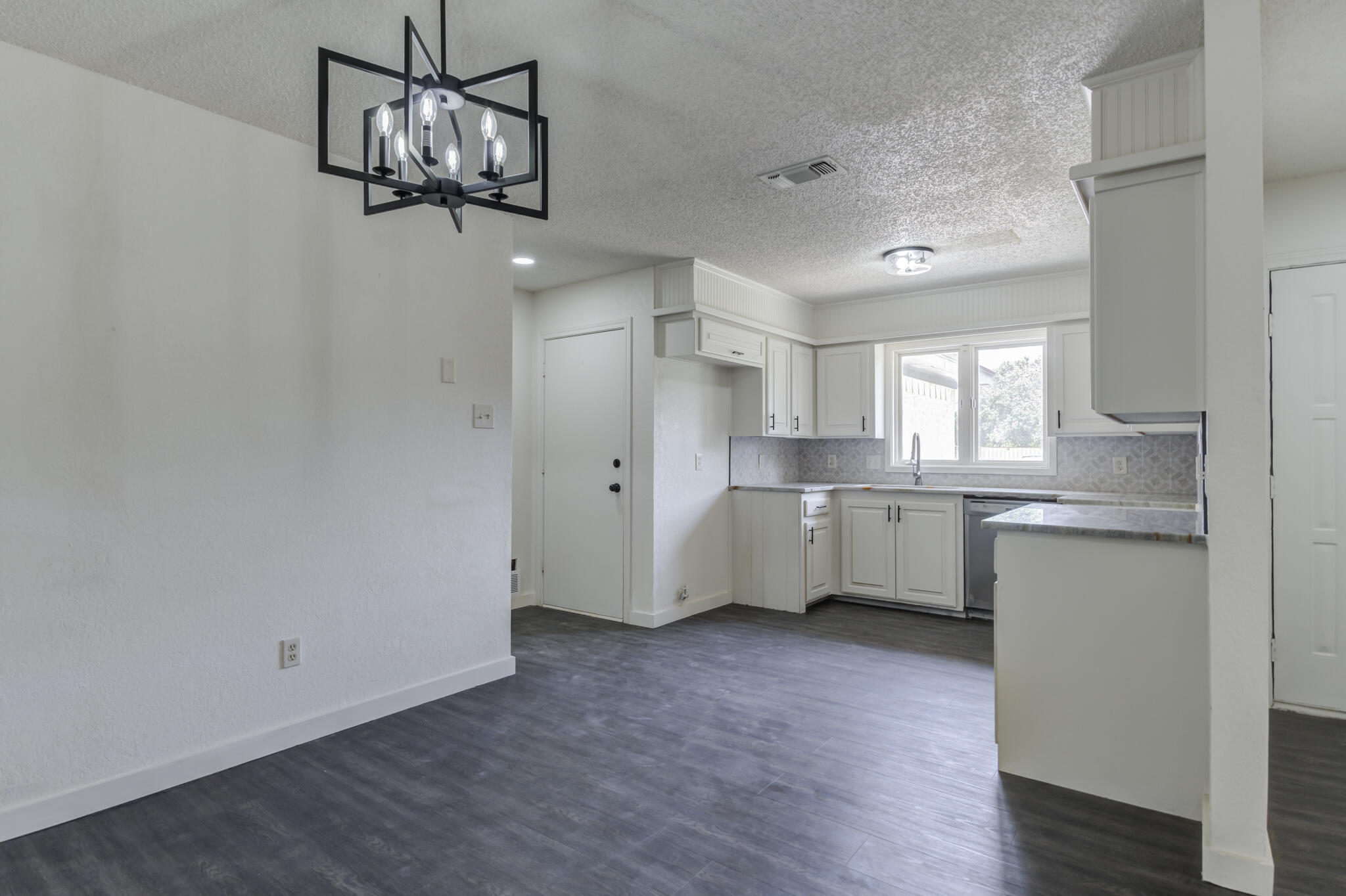 3006 93rd Street Lubbock, TX 79423 - Photo 14 of 35 a view of a kitchen with a sink dishwasher and wooden floor