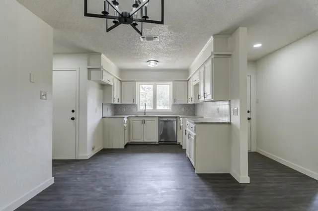 a kitchen with kitchen island white cabinets and stainless steel appliances