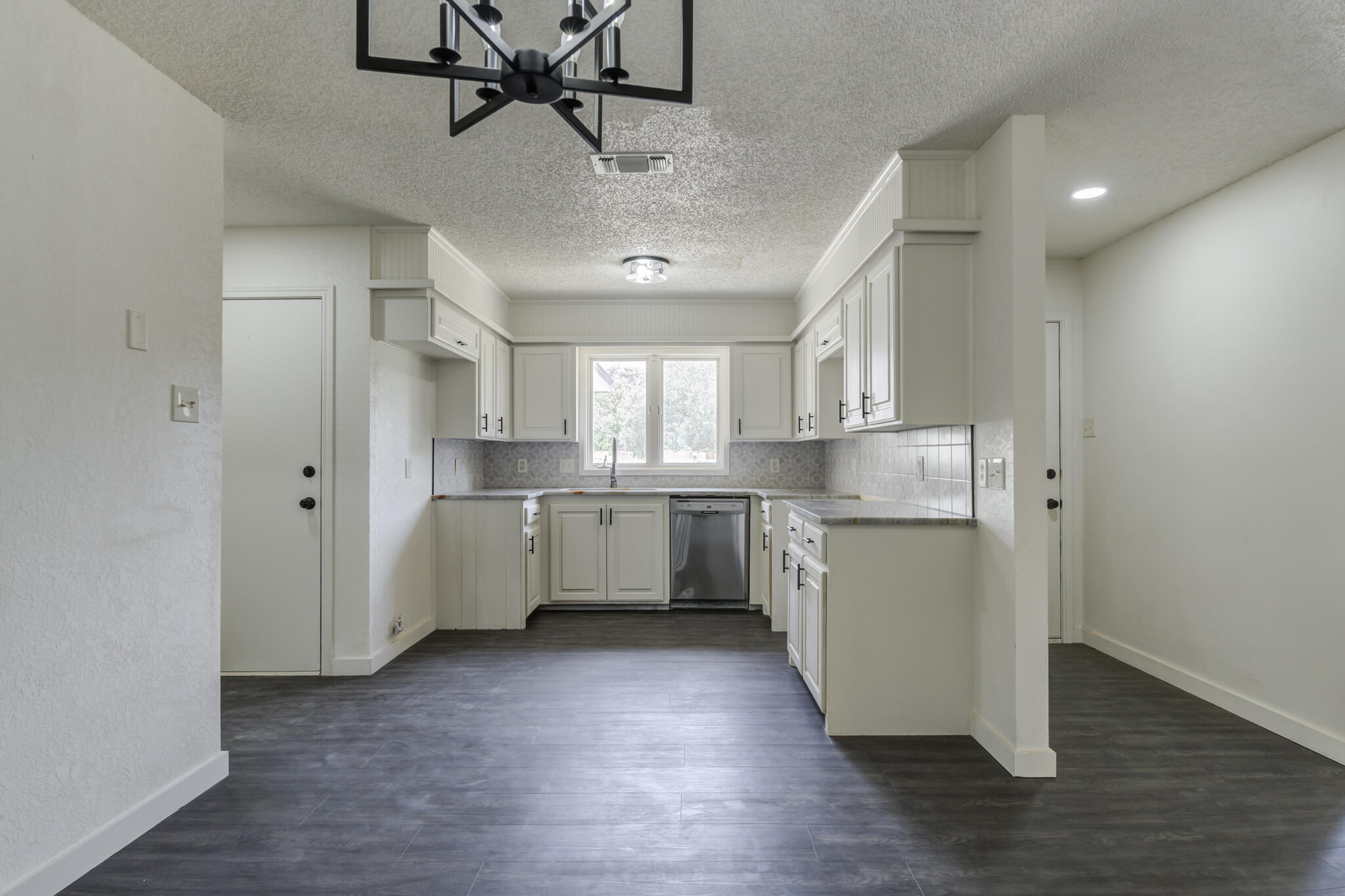 3006 93rd Street Lubbock, TX 79423 - Photo 15 of 35 a kitchen with kitchen island white cabinets and stainless steel appliances