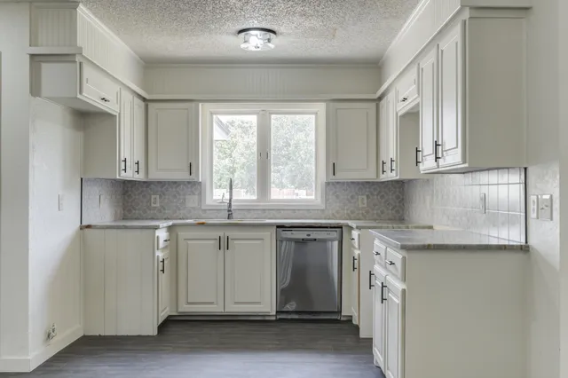 a kitchen with stainless steel appliances granite countertop a sink and cabinets with wooden floor
