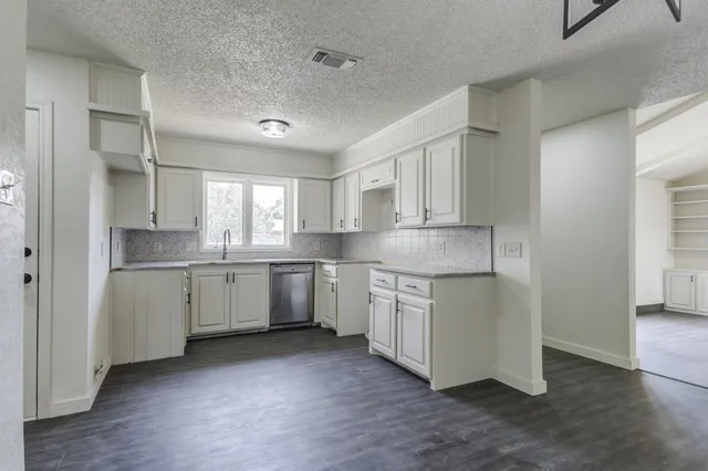 a kitchen with granite countertop white cabinets and white appliances