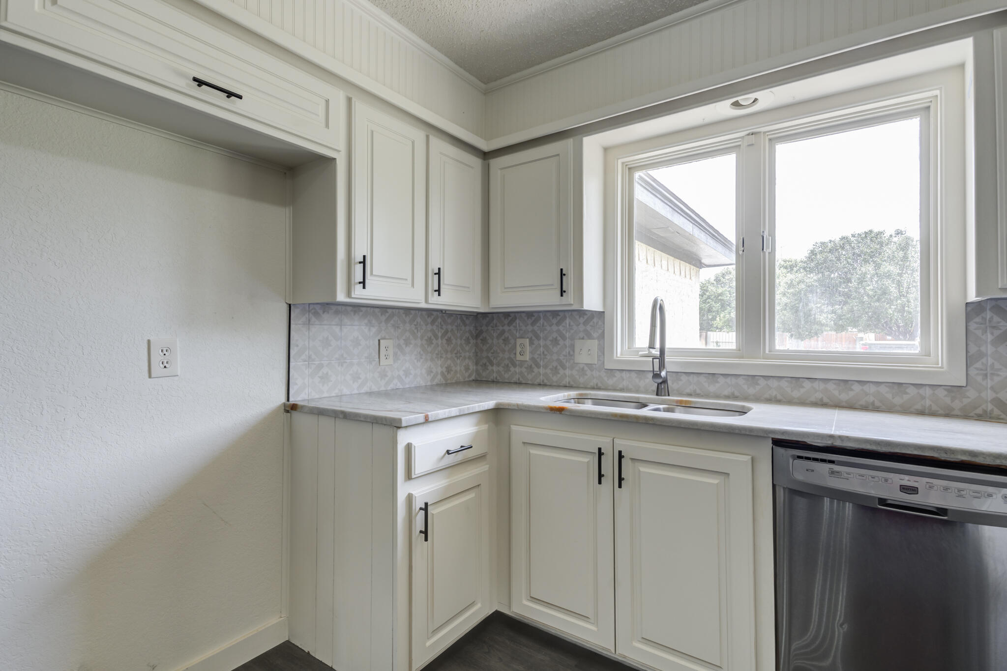 3006 93rd Street Lubbock, TX 79423 - Photo 20 of 35 a kitchen with stainless steel appliances granite countertop a sink and dishwasher next to a window